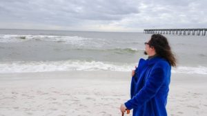 A portrait of a violent communist wearing a blue crushed velvet coat and holding an amber-handled cane, as he gazes out at the waves on Pensacola Beach, Florida on January 25, 2015.